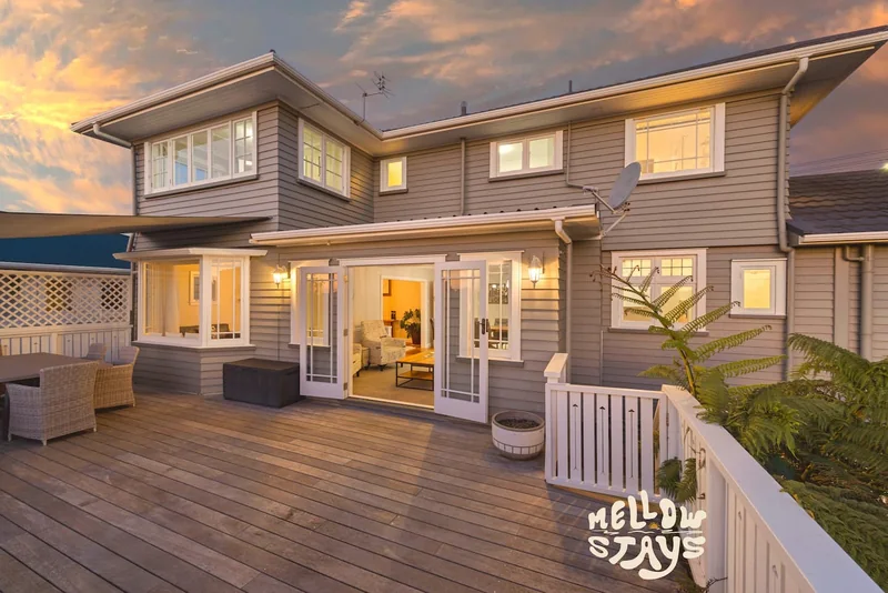 Deck and weatherboard exterior of Mellow Stays Te Henui Outlook at dusk